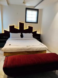 a bedroom with a large bed with a red rug at Hotel AK International - Chennai in Chennai