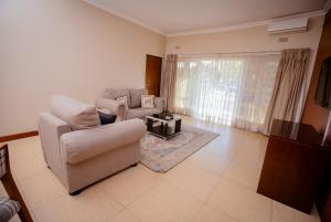 a living room with a couch and a chair at Krisstar Lodge in Blantyre