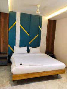 a bedroom with a white bed with a blue wall at Hotel AK International - Chennai in Chennai