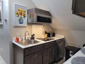 una pequeña cocina con fregadero y microondas en Brand new house with private bath in each room, en West Seneca