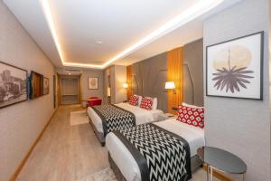 Habitación de hotel con 2 camas y sofá en Ramada Encore by Wyndham Istanbul Sisli en Estambul