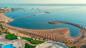 eine Luftansicht auf einen Strand mit Sonnenschirmen und dem Meer in der Unterkunft Sunrise Alma Bay Resort in Hurghada