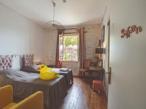 um quarto com um pato de borracha amarelo sentado numa cama em Le Grand Bassin em Castelnaudary