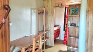 a room with a wooden table and a desk and shelves at Beats Of Beads Trust in Masai Mara
