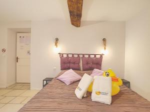 een slaapkamer met een groot bed met een gevulde eend erop bij Le Grand Bassin in Castelnaudary