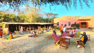 a group of people sitting in chairs in front of a stage at Beats Of Beads Trust in Masai Mara