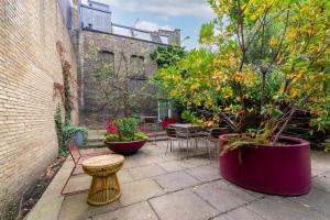 a patio with tables and chairs and plants at 5 Doughty Street in London