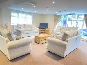 a living room with three chairs and a television at Whitton Lodge B&B in Chesterfield