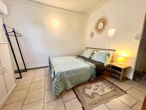 1 dormitorio con cama y espejo en la pared en Bonheur en Centre-Ville : Réservez votre Évasion F2 à Basse-Terre, en Basse-Terre