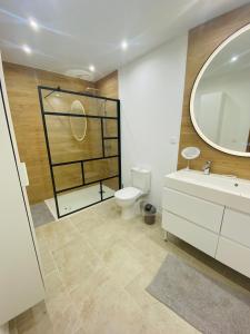 a bathroom with a toilet and a sink and a mirror at Villa Monbazillac, vue exceptionnelle, piscine, jacuzzi 10-16 pax in Monbazillac