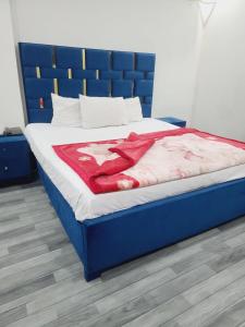 Safari Hotel في لاهور: سرير في غرفة مع اللوح الأمامي الأزرق