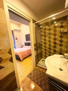 a bathroom with a shower and a sink and a bed at Casa AGNESE B&B in Naples