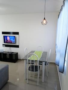 een eetkamer met een tafel en een tv bij Apartamento aconchegante Jd América in Maringá
