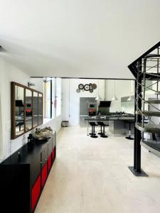 a large kitchen with a black and red counter at Le Loft -Superbe volume- in Saint-Étienne