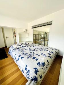 a bedroom with a bed with a blue and white comforter at Le Loft -Superbe volume- in Saint-Étienne