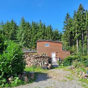 una casa de ladrillo con una valla y una pared de piedra en Sublime forêt, en Rendeux