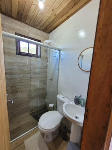 a bathroom with a toilet and a sink and a shower at Chalés Altos Da Montanha -K2 in Bom Jardim da Serra