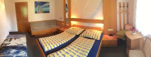 エック・アム・ファーカー・ゼーにあるPension Mühlenheimのベッド2台とソファが備わる客室です。