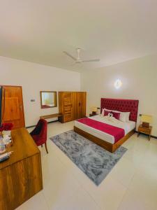een slaapkamer met een groot bed met een rood hoofdeinde bij Sunset Villa in Waskaduwa