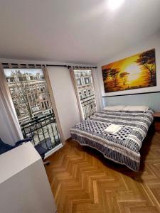 ein Schlafzimmer mit einem Bett und zwei großen Fenstern in der Unterkunft FUENCARRAL BARCELO Apartaments PARKING TPH in Madrid