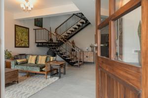齋浦爾的住宿－Villa Olives, Vanashraya，一间带楼梯和沙发的客厅
