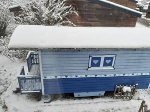 una casa azul con nieve encima en The Little Blue Caravan en Scy