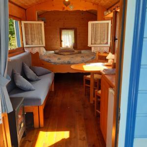 Una habitación con una cama y una mesa en una habitación en The Little Blue Caravan en Scy
