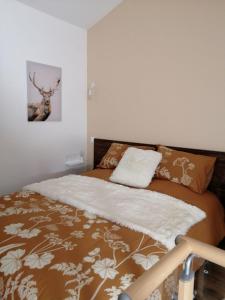 a bedroom with a bed with a deer picture on the wall at L'Embellie un gîte tout confort et cocooning in Villefranche-sur-Saône