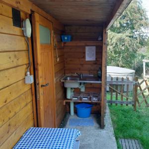 uma casa de banho num barracão de madeira com um lavatório em The Little Blue Caravan em Scy