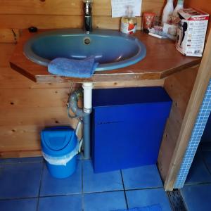 uma casa de banho com uma banheira azul e um WC. em The Little Blue Caravan em Scy