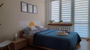 a bedroom with a blue bed with pillows on it at Apartament Nadstawna klimatyzowany in Biłgoraj