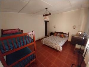 1 dormitorio con 2 literas y mesa en Hospedaje Casa Gaite en Maimará