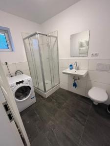 ein Badezimmer mit einer Waschmaschine und einem Waschbecken in der Unterkunft Rona 2xZimmerwohnung in Darmstadt
