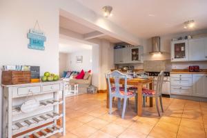 a kitchen and dining room with a table and chairs at Cornloft Cottage in South Creake