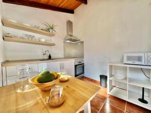 uma cozinha com uma mesa de madeira com uma taça de fruta em Teresitas Beach Escape Apartment em San Andrés