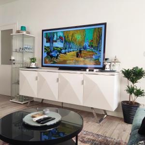 a living room with a tv on a white cabinet at Lovely home M&R in Split