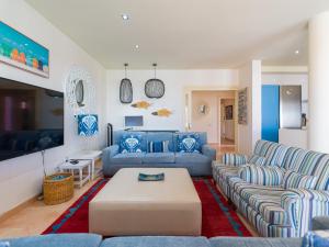 salon z niebieskimi kanapami i stołem w obiekcie Long Beach By CanariasGetaway w Corralejo