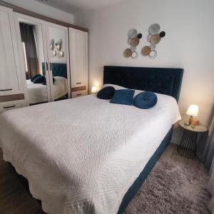 a bedroom with a large bed with blue pillows on it at Lovely home M&R in Split