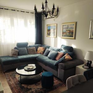 a living room with a blue couch and a table at Lovely home M&R in Split