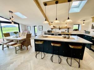 a kitchen with a large island with a table and chairs at Sheepfold Barn in Penruddock