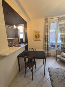 a kitchen and dining room with a table and chairs at B Appartement in Malakoff