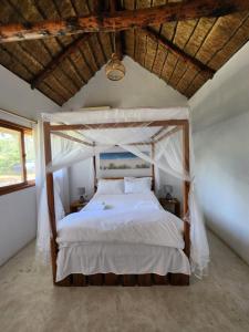 Cabo Conguiane的住宿－Cabana Beach Lodge，一间卧室配有一张带天蓬的床