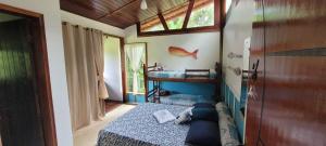 um quarto com uma cama, um lavatório e uma janela em Manacá Suítes Prumirim em Ubatuba