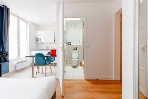 Pokój z łóżkiem i stołem oraz łazienką w obiekcie Le Studio Versaillais w Wersalu