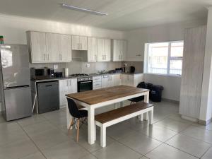 a kitchen with a wooden table and a table and chairs at Pokey Starfish Holiday Home in Franskraalstrand