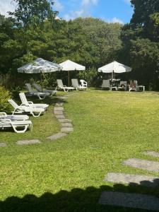 un grupo de sillas de césped y sombrillas en un patio en Parquemar R, en Punta del Este