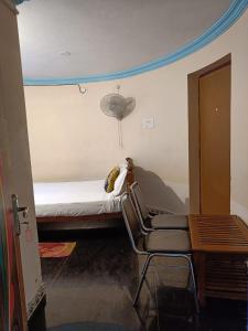 a room with a bed with two chairs and a table at Kottai Veedu Pondicherry in Pondicherry