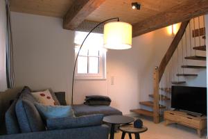 sala de estar con sofá, TV y escaleras en Ferienwohnung Emma, en Jork