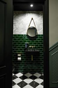 baño con lavabo negro y pared de ladrillo verde en The Portico Hotel, en Londres