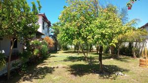 un giardino di fronte a una casa con alberi di Aconchego dos amigos a Beberibe